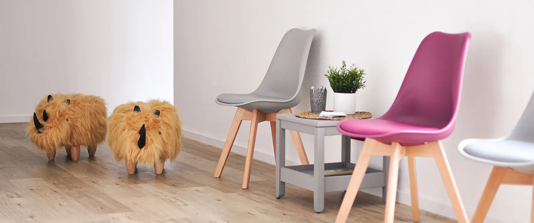 Wartebereich der Praxis Gelenkich mit Sitzgelegenheiten und dekorativen Hockern in ruhiger Atmosphäre.