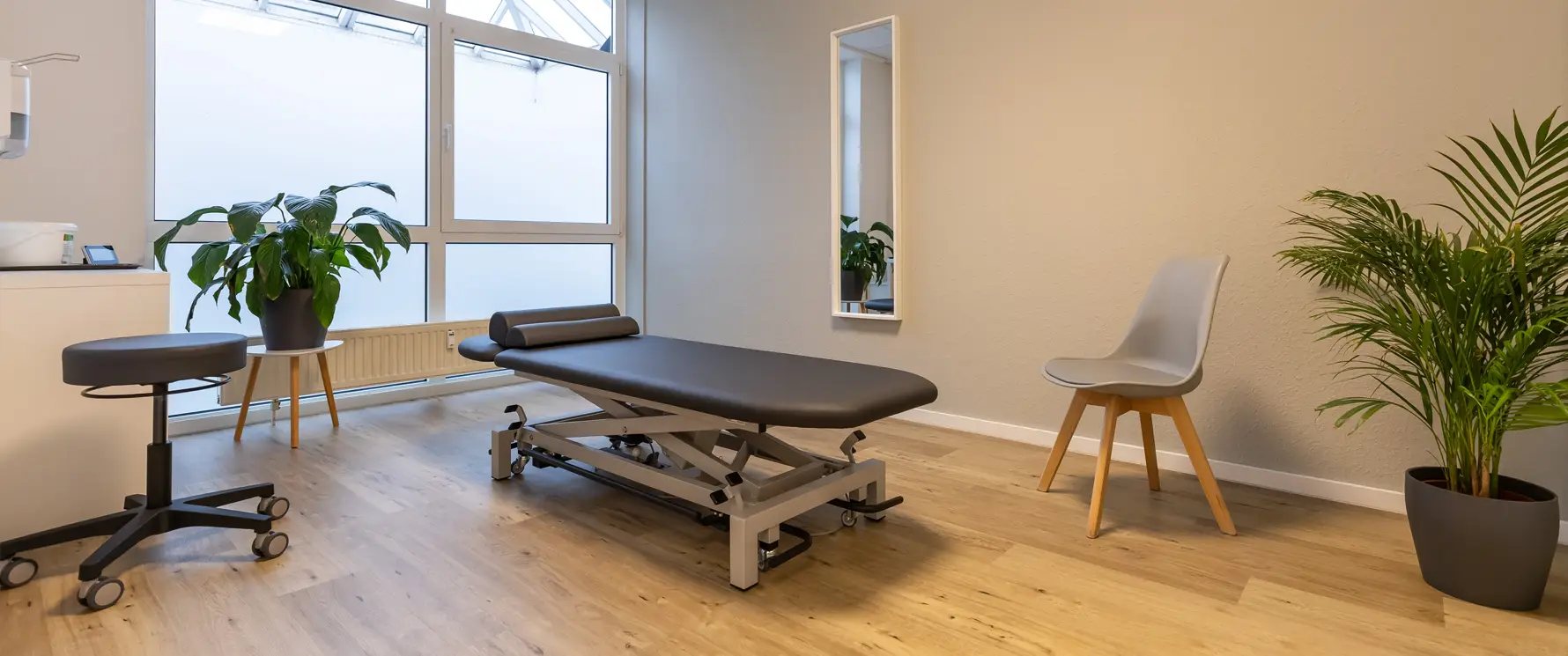 Heller Praxisflur mit Behandlungsräumen und Trainingsbereich in der Physiotherapiepraxis Gelenkich.